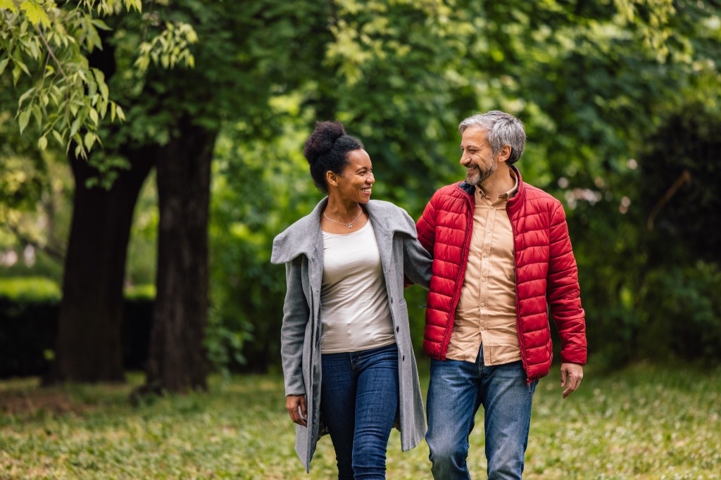 Healthy Maryland couple walking in a park after comparing health insurance